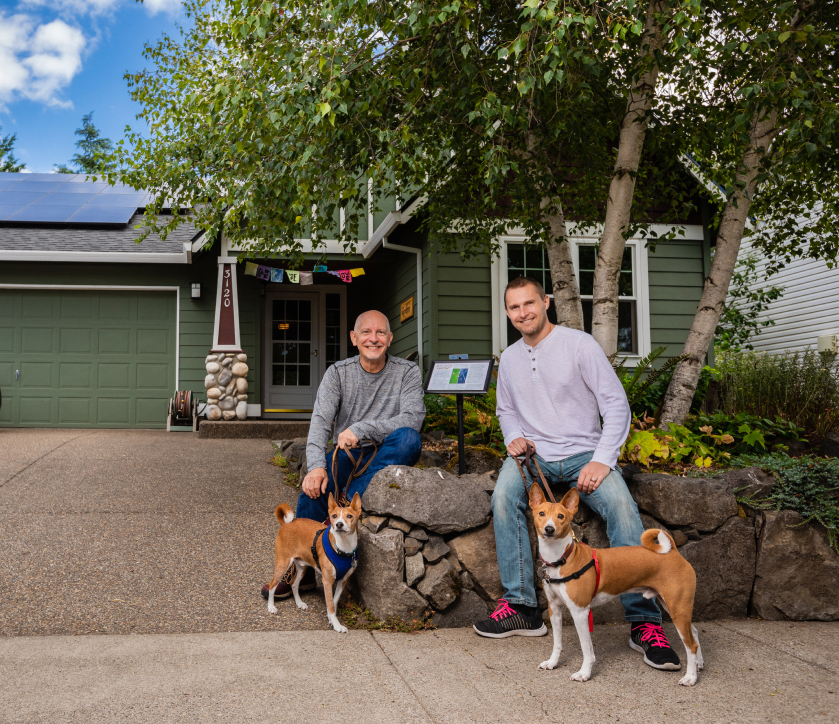 Older couple smiling with their dog.