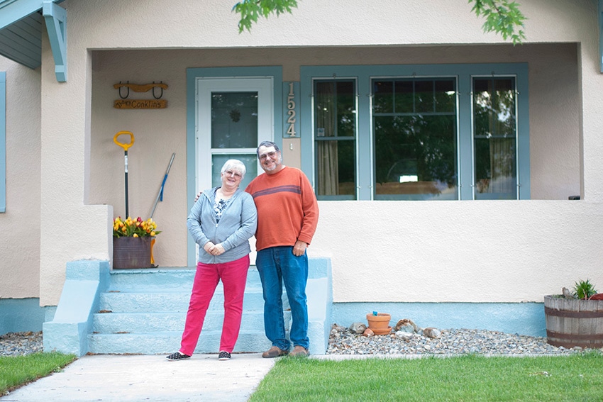 A couple standing in front of their home