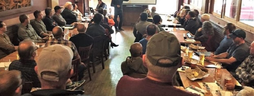 Group of people listening to a presentation made by a man