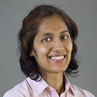 a woman with brown hair smiling at the camera