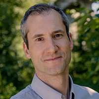 a man with gray hair smiling at the camera