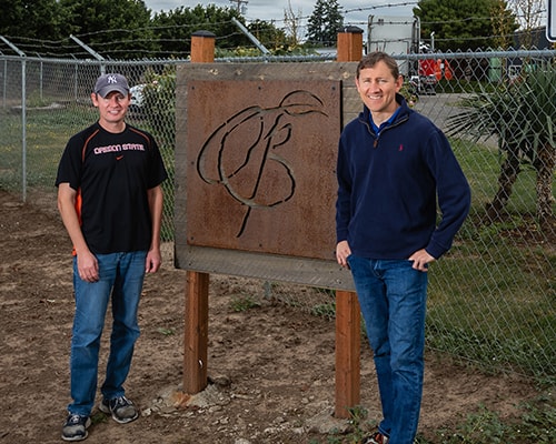 two men infront of a berry packing facility