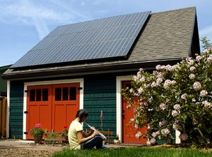 Girl playing flute in front of house with solar penls