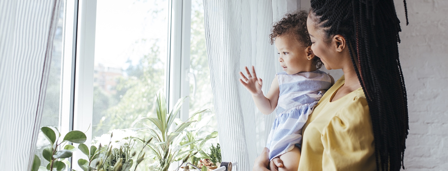 Mom and baby looking out window