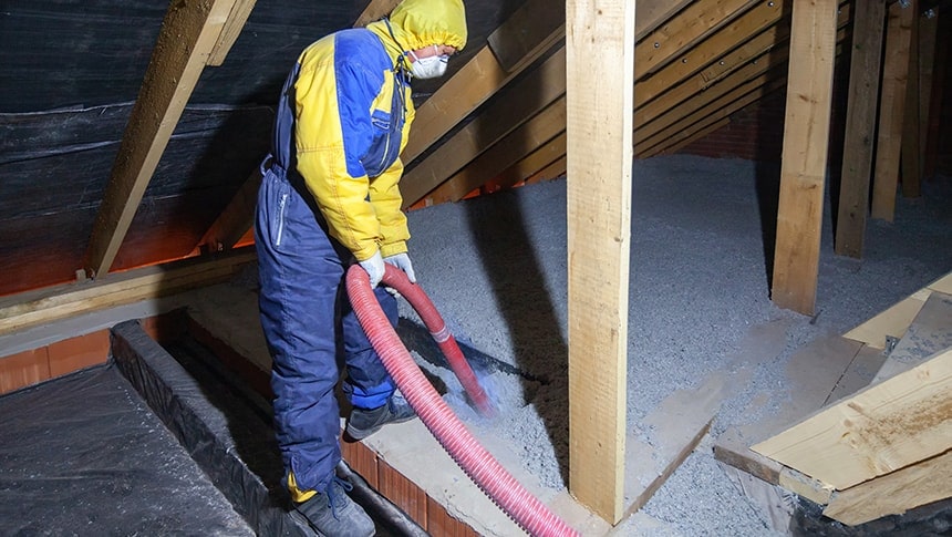 contractor blowing in insulation in attic