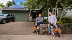 Male couple with dogs in front of home