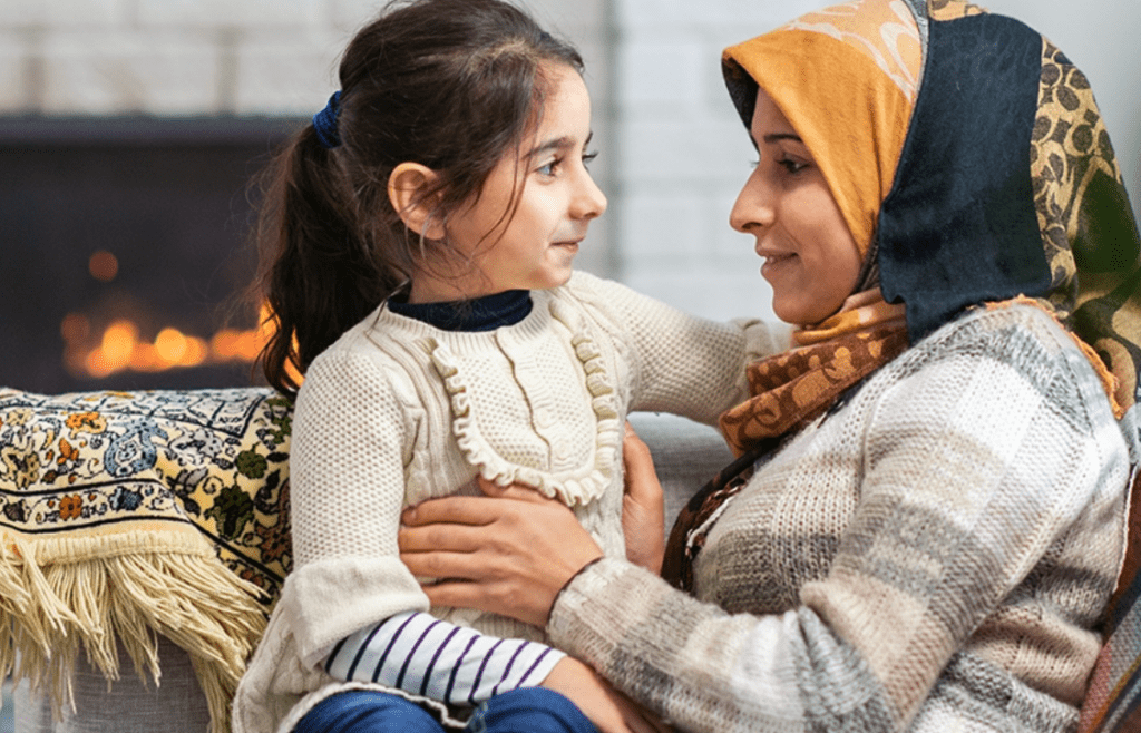 a woman and daughter in front of a fireplace