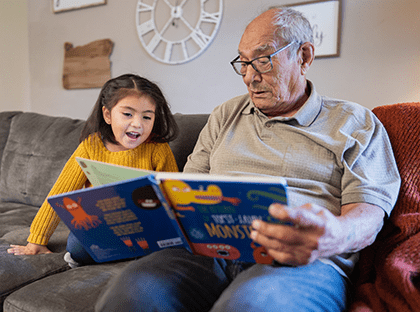 Grandfather reading to daughter