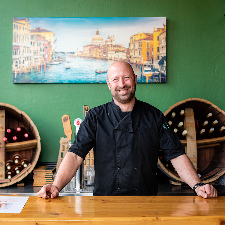 Man in front of wine barrels